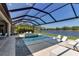 Beautiful pool and lanai area with comfortable lounge furniture and views of a serene lake at 9133 Warm Springs Cir, Parrish, FL 34219