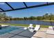 In-pool seating offers relaxing views of the lake in this beautiful lanai at 9133 Warm Springs Cir, Parrish, FL 34219