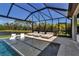 The screened-in pool area features lounge chairs in the water and a view of a tranquil lake at 9133 Warm Springs Cir, Parrish, FL 34219