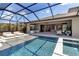 The covered patio features a large pool, hot tub, lounge chairs, and views of the lake at 9133 Warm Springs Cir, Parrish, FL 34219