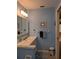 Bathroom featuring blue walls, light fixtures and a cabinet mirror above the sink at 9208 37Th N St, Pinellas Park, FL 33782