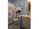 Well-lit bathroom with seashell decorations, blue walls and tile flooring, plus a cabinet on top of the toilet at 9208 37Th N St, Pinellas Park, FL 33782