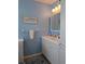 Bathroom with blue walls, gray carpet and a wide cabinet mirror above the sink at 9208 37Th N St, Pinellas Park, FL 33782