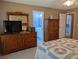 Bedroom with warm colors, comfortable furniture and open doorways to the bathroom and hallway at 9208 37Th N St, Pinellas Park, FL 33782