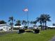 Welcoming community entrance with lush lawns, palm trees, and American flag waving proudly at 9208 37Th N St, Pinellas Park, FL 33782