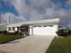 Charming single-story home with a well-manicured lawn, a white roof, and an attached garage at 9208 37Th N St, Pinellas Park, FL 33782
