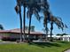 This community building features a red tile roof, lush landscaping, an American flag and mature palms on a bright day at 9208 37Th N St, Pinellas Park, FL 33782