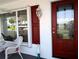 Charming red front door with sidelight, enhancing curb appeal and welcoming guests at 9208 37Th N St, Pinellas Park, FL 33782