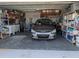 Front view of a garage with a car parked inside, shelves and storage are on the sides at 9208 37Th N St, Pinellas Park, FL 33782