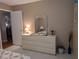 Serene main bedroom featuring a dresser with a decorative mirror and a glimpse of the connected living area at 9208 37Th N St, Pinellas Park, FL 33782