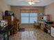 Functional home office featuring patterned tile floors, a window with blinds, and multiple work surfaces at 9208 37Th N St, Pinellas Park, FL 33782