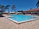 The outdoor pool is a refreshing oasis, surrounded by a deck, lounge chairs, and a clear blue sky for relaxation at 9208 37Th N St, Pinellas Park, FL 33782