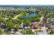 Stunning aerial view of a home with a sparkling pool and lush landscaping nestled near a serene lake and green spaces at 6711 3Rd N St, St Petersburg, FL 33702