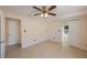 Neutral bedroom with tile floors, ceiling fan with light, multiple doors, and large window in back room at 6711 3Rd N St, St Petersburg, FL 33702