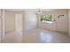 Neutral empty room featuring a ceiling fan, tiled floors, and natural light streaming through the large windows at 6711 3Rd N St, St Petersburg, FL 33702