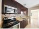 Modern kitchen with stainless steel appliances, granite countertops, and dark wood cabinetry at 6711 3Rd N St, St Petersburg, FL 33702