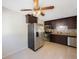 This kitchen shows stainless steel appliances, dark cabinetry, tile floors, and a ceiling fan with light at 6711 3Rd N St, St Petersburg, FL 33702