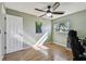 Bedroom featuring laminate wood flooring, a ceiling fan, a window, and a poster on the green wall at 10654 117Th Way, Seminole, FL 33778