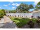 Well-maintained backyard with a white vinyl fence, landscaped garden beds, and a stone path amidst lush green grass at 10905 Elliot St, Riverview, FL 33578