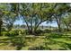 Spacious backyard featuring a well-manicured lawn and mature trees, with a view of the waterfront at 10905 Elliot St, Riverview, FL 33578