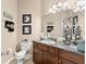 Well-lit bathroom featuring a vanity with a dark granite countertop and decorative accents at 10905 Elliot St, Riverview, FL 33578