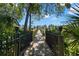 Scenic boardwalk lined with lush greenery and a black metal fence, leading towards a waterfront view at 10905 Elliot St, Riverview, FL 33578