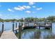 Wooden dock on calm water, featuring wooden pilings and metal boat lifts, with distant views of waterfront homes at 10905 Elliot St, Riverview, FL 33578