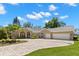 Attractive one-story house with a circular driveway, mature trees, and manicured lawn at 10905 Elliot St, Riverview, FL 33578