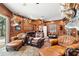 Warm living room boasting wood paneling, leather seating, a fireplace, and ample space for relaxation and entertainment at 10905 Elliot St, Riverview, FL 33578