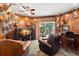 Unique living room with wood paneled walls, leather furniture, and a view of the pool area from the sliding glass doors at 10905 Elliot St, Riverview, FL 33578