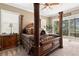 Comfortable primary bedroom showcasing an ornate bed, ceiling fan and a lake view at 10905 Elliot St, Riverview, FL 33578