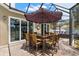 Charming outdoor dining area with seating for ten, shaded by an umbrella on a brick-paved patio at 10905 Elliot St, Riverview, FL 33578