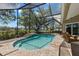 Serene screened-in pool featuring a waterfall and stunning views of the water at 10905 Elliot St, Riverview, FL 33578