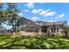 Screened in pool and patio area with a view of the landscaped yard around the home and the dark metal fence at 10905 Elliot St, Riverview, FL 33578