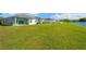 Lush green backyard with pond view. Houses in distance at 11221 Gold Compass St, Gibsonton, FL 33534