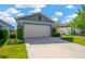 Attractive home featuring a two-car garage, stone accents, and neatly trimmed landscaping at 11221 Gold Compass St, Gibsonton, FL 33534