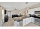 Open-concept kitchen featuring stainless steel appliances, granite counters, and views to the living area at 11221 Gold Compass St, Gibsonton, FL 33534