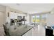 Bright kitchen featuring stainless steel appliances, granite counters, an island, and pond views at 11221 Gold Compass St, Gibsonton, FL 33534