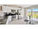 Bright kitchen with stainless appliances, granite counters, white cabinets, and backyard pond views at 11221 Gold Compass St, Gibsonton, FL 33534