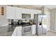 Modern kitchen featuring stainless steel appliances, granite countertops, and white cabinets at 11221 Gold Compass St, Gibsonton, FL 33534