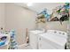 Functional laundry room with a washer, dryer, and shelving for storage at 11221 Gold Compass St, Gibsonton, FL 33534