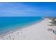 Scenic aerial view of a pristine white sand beach meeting a clear blue ocean at 121 46Th Ave # 2H, St Pete Beach, FL 33706