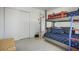 Bedroom featuring a bunk bed, closet, and terrazzo flooring, providing a comfortable space at 121 46Th Ave # 2H, St Pete Beach, FL 33706