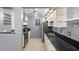 Efficient kitchen with black counters, a stainless steel refrigerator, and ample cabinet space for easy organization at 121 46Th Ave # 2H, St Pete Beach, FL 33706