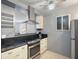 Modern kitchen featuring a stainless steel range hood, black countertops, and sleek appliances, perfect for cooking at 121 46Th Ave # 2H, St Pete Beach, FL 33706