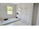 Modern bathroom featuring gray patterned tile, large windows, and sleek, contemporary fixtures at 1405 50Th N Ave, St Petersburg, FL 33703
