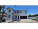 Charming two-story home featuring a modern design, attached garage, and framed by a clear blue sky at 1405 50Th N Ave, St Petersburg, FL 33703
