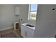 Laundry room features a window, white cabinetry, and stainless steel fixtures. Under construction at 1405 50Th N Ave, St Petersburg, FL 33703