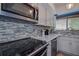 Modern kitchen featuring granite countertops, stainless appliances, and tiled backsplash at 1500 Sunset Rd # G4, Tarpon Springs, FL 34689
