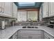 Close up of kitchen sink with granite countertops, stylish faucet, and white cabinetry at 1500 Sunset Rd # G4, Tarpon Springs, FL 34689